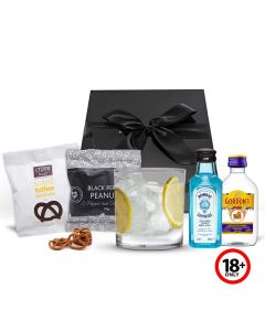 Gin gift set with short tumbler glass and gourmet treats.