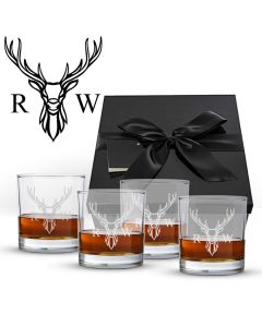 four tumblers with initials engraved on the glass, all in front of a black gift box