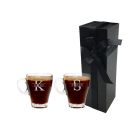 Personalised glass cup that can be used for any hot drink. Engraved with any names and initials, this picture shows two cups standing in front of a tall and thin black box with a white background