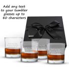 four tumblers with any text engraved on the glass, all in front of a black gift box